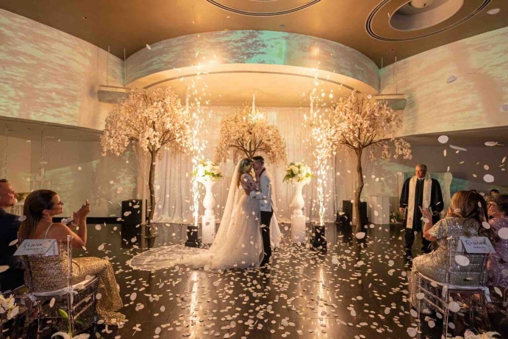 Ceremonia de boda con bengalas frías y pétalos cayendo en Aqua Reception Hall en Miami