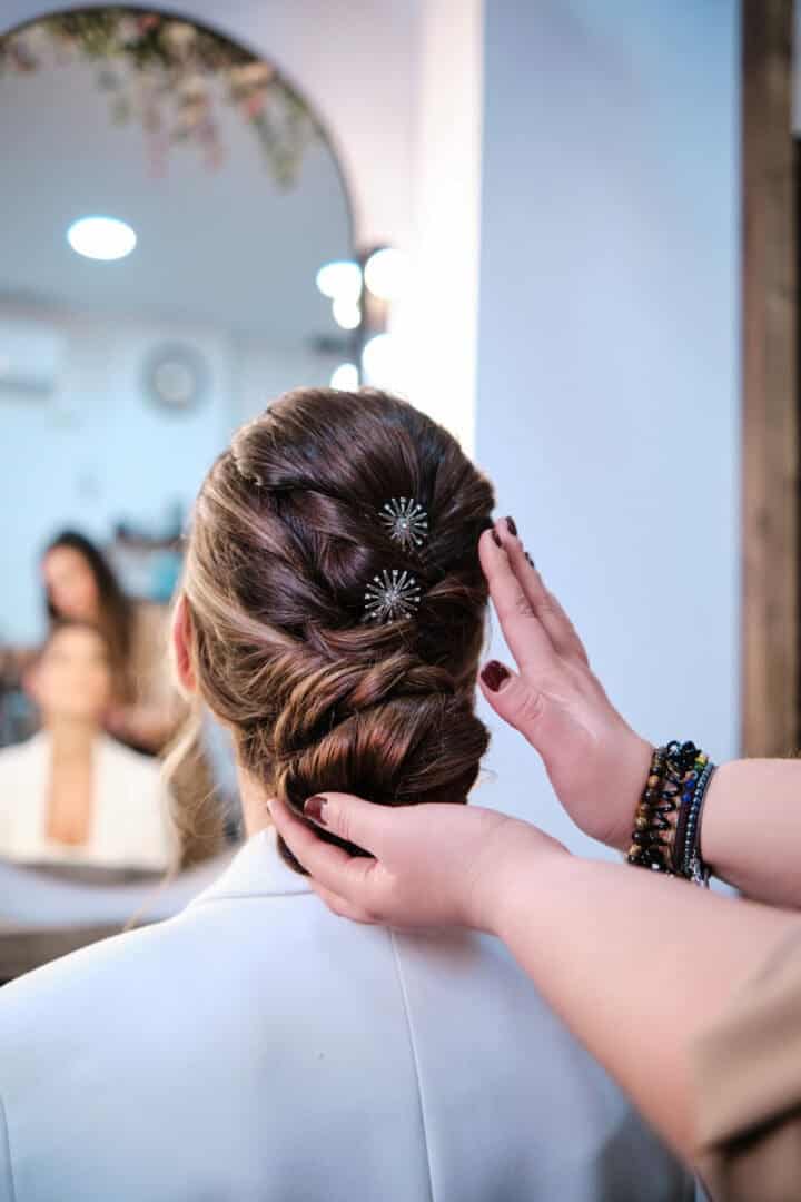 Hairdresser finishing a stylish hairstyle for a client in the beauty salon. Hairstyle and hairdressing concept.