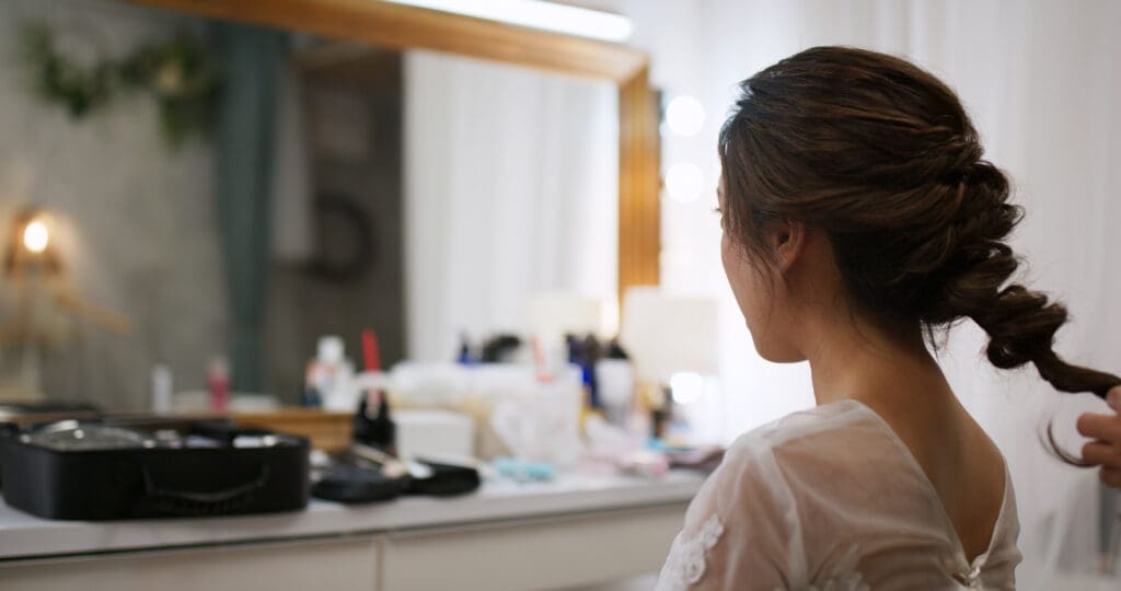 Hairdresser making hairstyle on bride in beauty salon